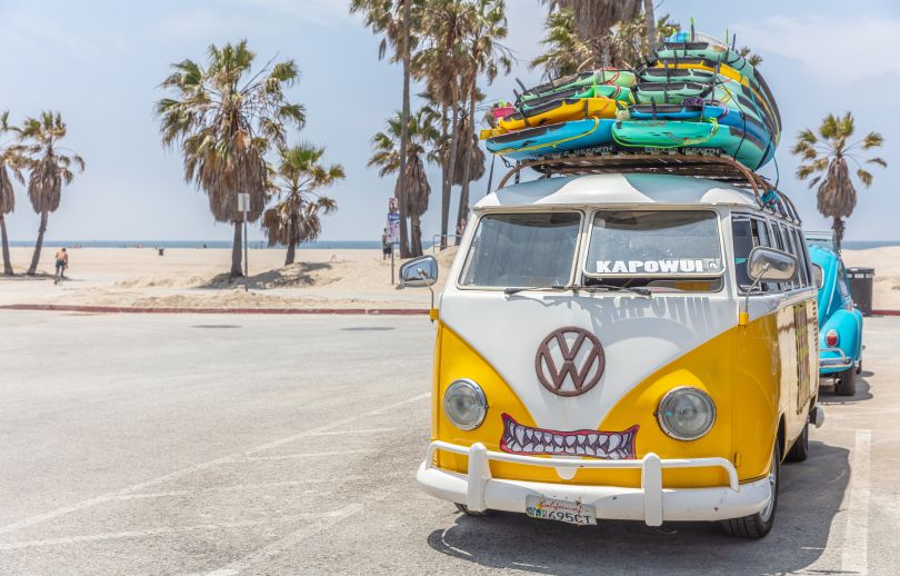 阳光明媚的春日，黄色货车车顶上堆放着冲浪板。威尼斯海滩，美国加利福尼亚州。通过Adobe Stock授权的图像，由Rawf8提供。
